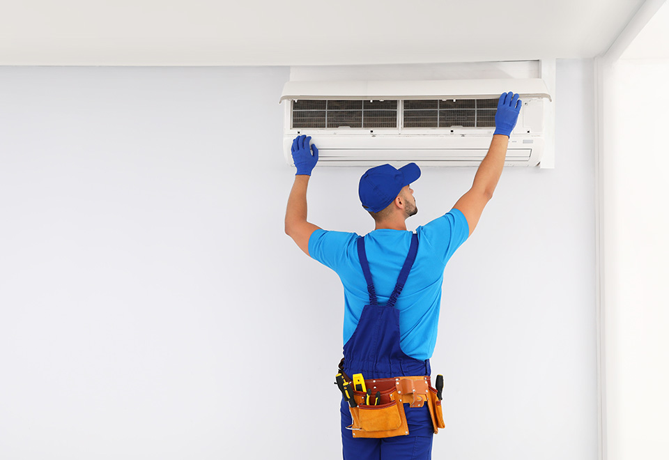 man fitting an air conditioner to a wall